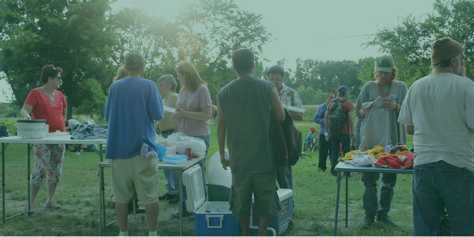 Volunteers handing out food and clothing outdoors