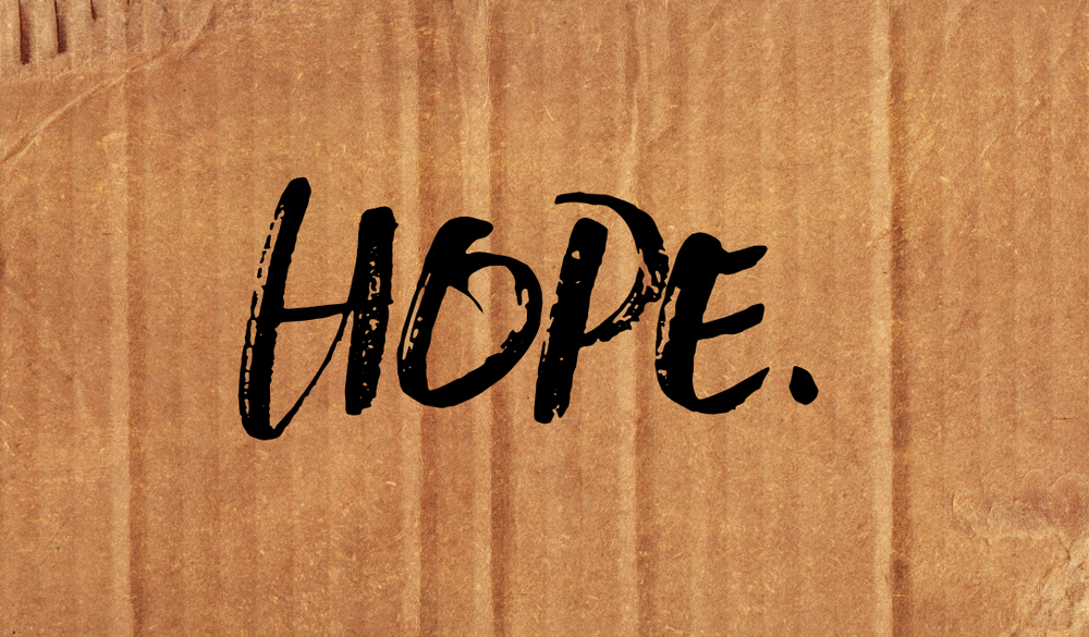 The word HOPE hand-lettered on cardboard