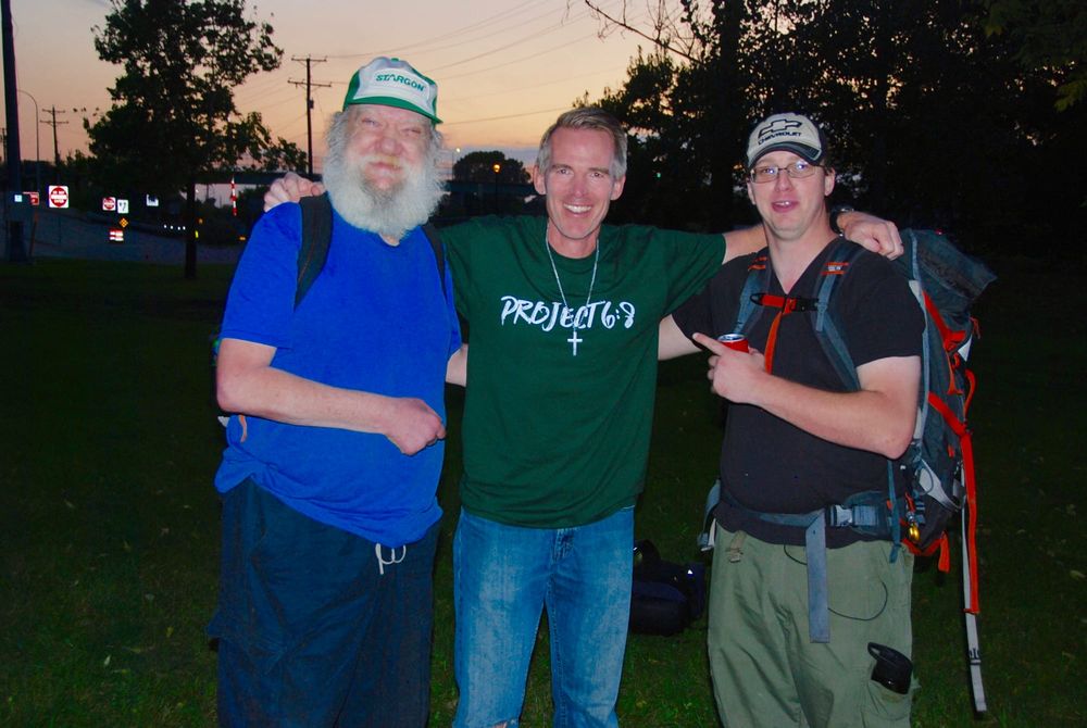 A Project 6:8 volunteer with two friends at dusk